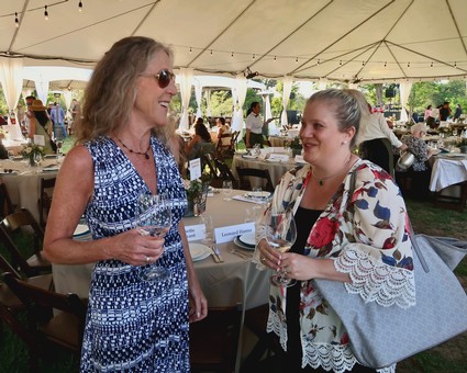 Two women enjoying wine at a Lodi Winegrape Commission outdoor event.