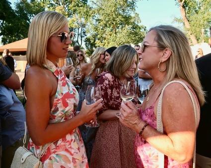 Women enjoying wine tasting at a Lodi Winegrape Commission event outdoors.