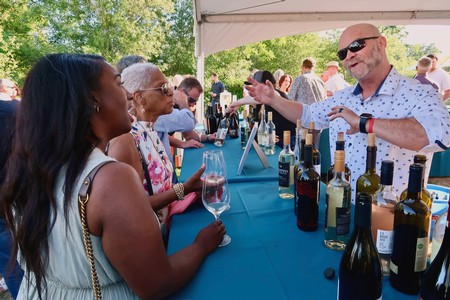 People enjoying wine tasting at Lodi Winegrape Commission event outdoors.