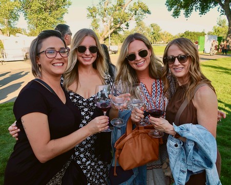 Group of women enjoying wine tasting outdoors at Lodi Winegrape Commission event.