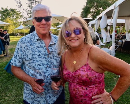 Smiling man and woman enjoying wine at Lodi Winegrape Commission event outdoors.