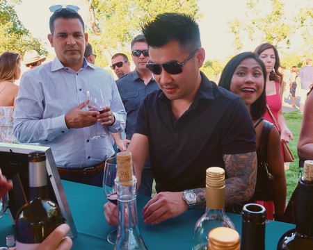 People enjoying wine tasting at a Lodi Winegrape Commission event outdoors.