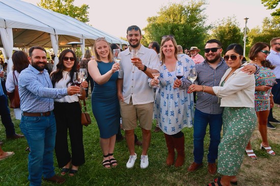 Group of people enjoying wine tasting outdoors at Lodi Winegrape Commission event.