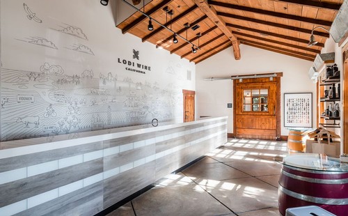 Interior of Lodi Winegrape Commission with wooden accents and wine barrels, showcasing wine industry heritage.
