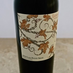 Lodi Petite Sirah wine bottle with decorative label featuring grapevine and leaf design, vintage 2014, from Lodi Winegrape.