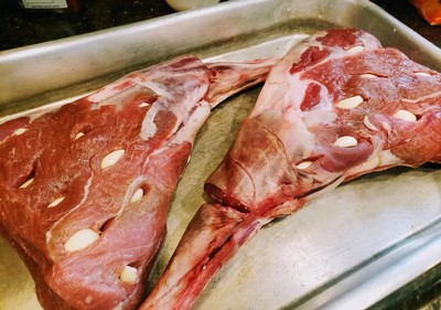 Raw lamb chops with bone-in, ready for preparation, on a metal tray.