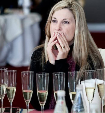 Woman tasting wine at a Lodi Winegrape Commission event with multiple wine glasses in front.
