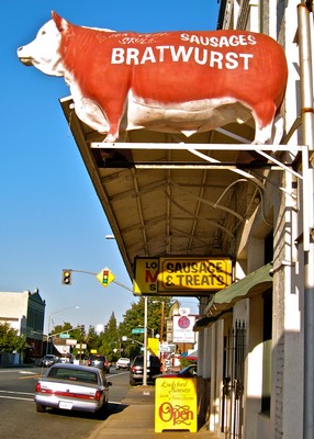 Sign for sausage and bratwurst at Lodi Winegrape Commission with a pig illustration.