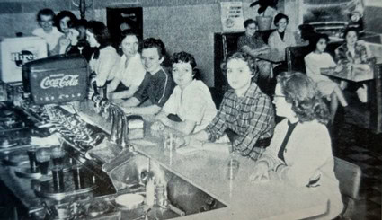 Historical photo of a group of people at a bar or restaurant, possibly related to Lodi Winegrape Commission activities.