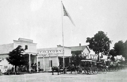 Black and white photo of the historic C.C. Ivory General Merchandise Store with horse-drawn carriages.