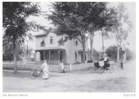 Black and white photo of Dr. Mason's house in Lodi, California, with people and bicycles in front.