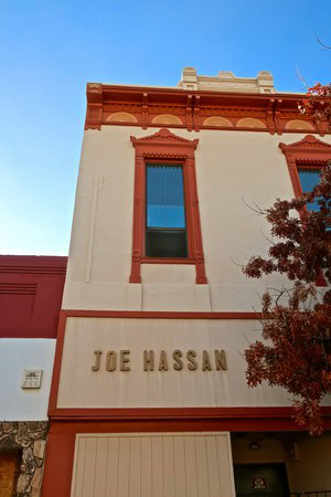 Historic Joe Hassan building with red trim and blue sky in Lodi wine country, California.