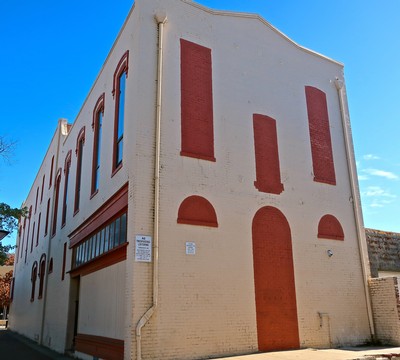 Old brick building with red accents in Lodi, California, under a clear blue sky.