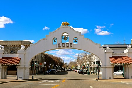 Iconic Lodi Wine Country gateway arch with bells and city name in downtown Lodi, California.