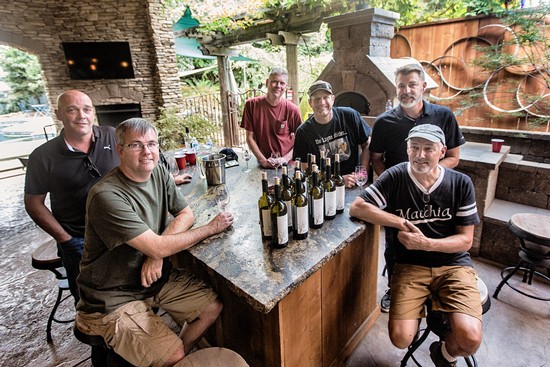 Group of men enjoying wine tasting at Lodi Winegrape Commission event.