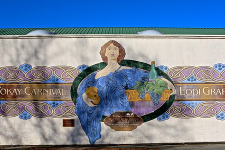 Colorful mural of a woman holding a wine glass and grapes at Lodi Winegrape Commission.