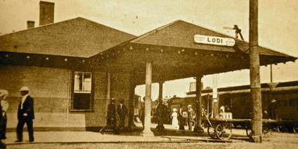 Vintage photo of Lodi train station with people and bicycles, early 20th century transportation hub.