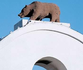 Bear sculpture on top of a white building with a blue sky background, representing Lodi Winegrape Commission.