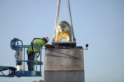 Worker inspecting a large metallic wine fermentation tank at a vineyard in Lodi, California.