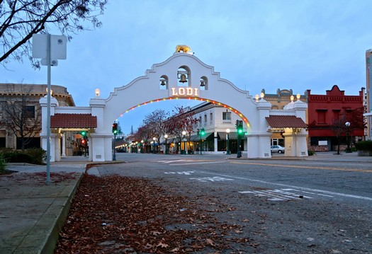 Lodi Winegrape Commission entrance archway in downtown Lodi, California, with festive lights and historic architecture.