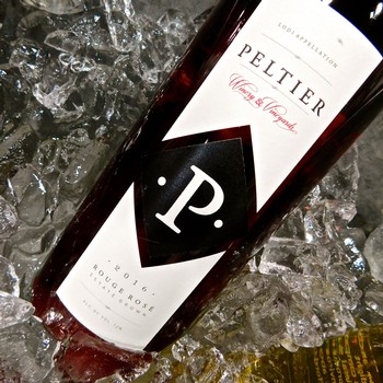 Close-up of a Peltier wine bottle on ice, showcasing the label and branding for SEO.