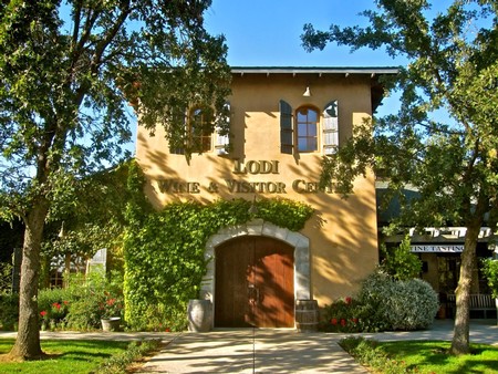 Historic building of the Lodi Winegrape Commission surrounded by trees and greenery in Lodi, California.