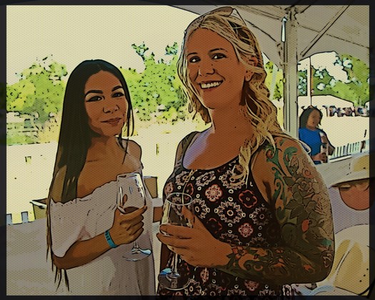 Two women enjoying wine at a Lodi wine event, smiling and holding wine glasses outdoors.