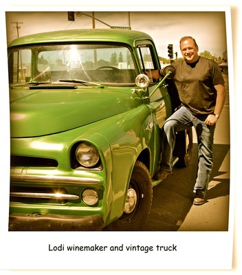 Lodi winemaker standing next to a vintage green truck, showcasing local wine production heritage.