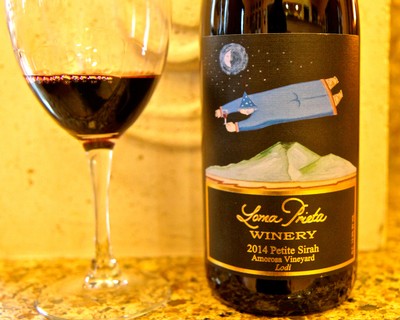 Bottle of Lodi Petite Sirah wine from Loma Prieta Winery with a glass of red wine.