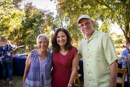 Smiling group of three people at Lodi Winegrape Commission outdoor event.
