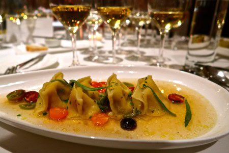 Elegant dish with dumplings, vegetables, and wine glasses in the background for Lodi Winegrape Commission.