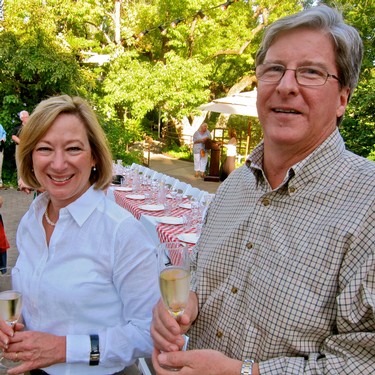 Two people enjoying a wine tasting outdoors at a Lodi Winegrape Commission event.