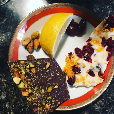 Chocolate, lemon, and dried cherries on a decorative plate for wine pairing.