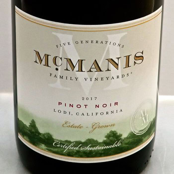 Close-up of McManis 2017 Pinot Noir wine bottle from Lodi, California, showcasing the label and vineyard details.