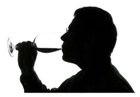 Silhouette of a person tasting wine from a glass, emphasizing wine appreciation and quality.