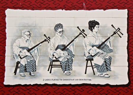 Three women playing traditional shamisen instruments at Lodi Obon Festival in California.