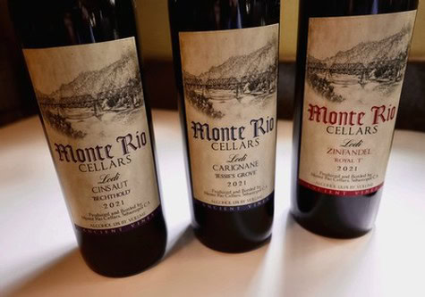 Three bottles of Lodi Winegrape Commission wine with scenic vineyard labels, showcasing local wine production.
