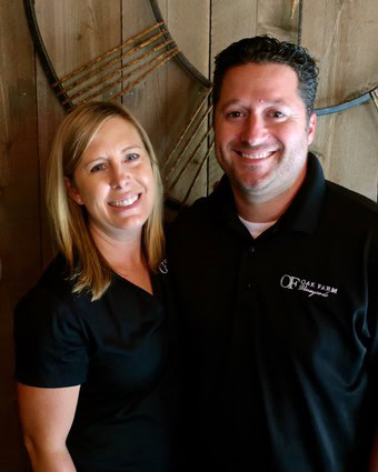 Smiling man and woman in black shirts at Lodi Winegrape Commission event.