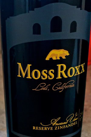 Close-up of Moss Roxx Reserve Zinfandel wine bottle from Lodi, California, showcasing the label and branding.
