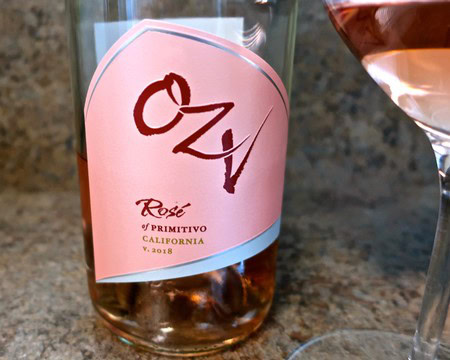 Close-up of a rosé wine bottle from Lodi Winegrape Commission with a glass of rosé wine nearby.