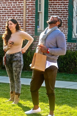 Two people enjoying wine outdoors in Lodi, California, with a brick building in the background.
