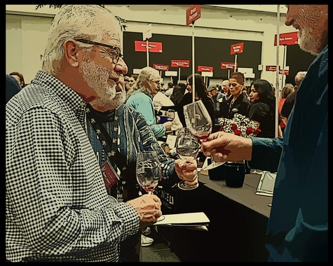 Older man with glasses tasting wine at Lodi Winegrape Commission event with diverse attendees in background.