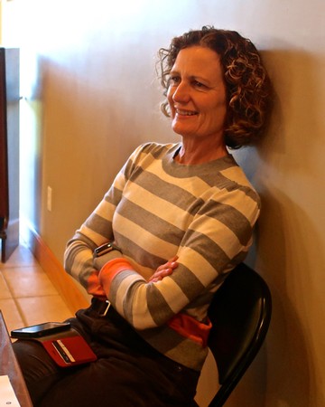 Smiling woman with curly hair in striped sweater at Lodi Winegrape Commission event.