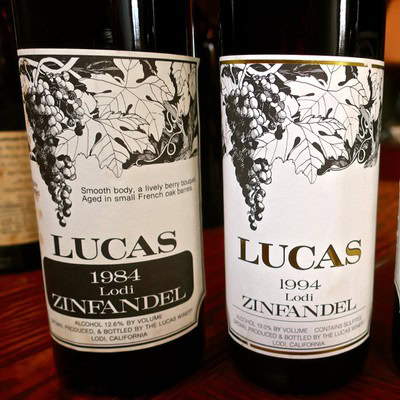 Two Lucas Zinfandel wine bottles from Lodi, California, showcasing vintage labels from 1984 and 1994.