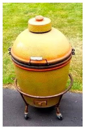 Large ceramic smoker grill on wheels for outdoor barbecue cooking and smoking meats.