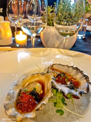 Close-up of fresh oysters with garnishes on a dinner table at Lodi Winegrape Commission event.
