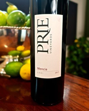 Bottle of Mencia wine from Lodi Winegrape Commission, vintage 2017, with fresh fruits in background.