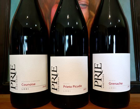 Three bottles of Pride wine from Lodi, including Conouise, Prieto Picudo, and Grenache, displayed on a shelf.