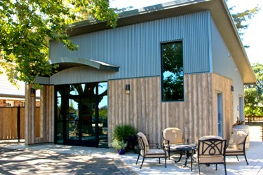 Modern office building of the Lodi Winegrape Commission with outdoor seating and trees in the background.