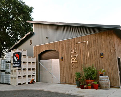 Lodi Winegrape Commission building with wooden exterior and potted plants in front, promoting sustainable wine grape farming.
